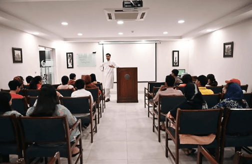 A speaker addressing students at a Debate Room training session in Lahore